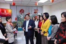 Le PM Pham Minh Chinh encourage et adresse ses vœux de Nouvel An aux journalistes du Département des informations internationales de l’Agence vietnamienne d’information (VNA). Photo : VNA.