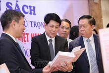 Luong Cuong, membre du Bureau politique, permanent du Secrétariat (centre) et Nguyen Trong Nghia, membre du Bureau politique, secrétaire du Comité central du Parti et chef de la Commission centrale de propagande et d'éducation (droite) lors de la zone d'exposition de livres. Photo : VNA.