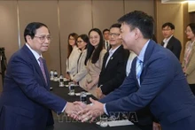 Le PM vietnamien Pham Minh Chinh (à gauche) serre la main des membres du groupe VietTech NZ. Photo : VNA.