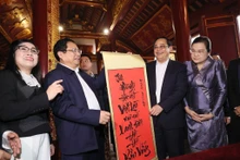 Le PM vietnamien, Pham Minh Chinh, offre à son homologue laotien, Sonexay Siphandone, une calligraphie en vietnamien signifiant que l’amitié vietnamo-lao à jamais verte et éternellement solide, le 7 janvier à Hanoi. Photo : VNA.