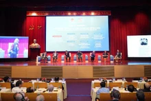 Les experts échangent lors du colloque scientifique international "50 ans de réunification nationale : Le rôle de la diplomatie dans la construction de la paix, hier et aujourd'hui". Photo : nhandan.vn