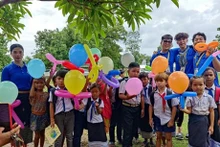 Des jeunes volontaires de Hô Chi Minh-Ville et des enfants lao dans une aire de jeux. Photo: CVN