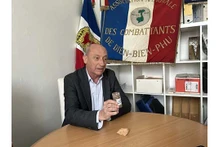 Le général Philippe de Maleissye présente le pot de terre et une pierre qu'il a rapportés de la colline A1 à Diên Biên Phu. Photo : VNA.