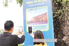 Les touristes scannent les codes QR pour découvrir les informations touristiques dans la zone touristique du cap Sa Vi, Mong Cai. Photo : NDEL.