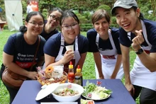 Des membres du consulat britannique apprennent à cuisinier le "phở". Photo : VNA.