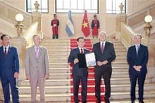 Le Président de l’Assemblée nationale du Vietnam (ANV), Vuong Dinh Huê (au milieu), reçoit le titre d’invité d’honneur décerné par le gouverneur de la province argentine de Santa Fe, Omar Ángel Perotti. Photo : VNA.