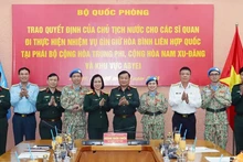 Lors de la cérémonie pour remettre à trois officiers les décisions du président de la République et du ministre de la Défense concernant leur participation à la Mission multidimensionnelle intégrée des Nations unies. Photo : VNA.