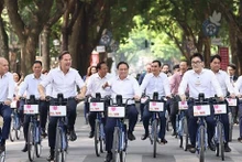 Les Premiers ministres vietnamien et néerlandais font du vélo ensemble dans des rues de Hanoï. Photo : VNA.