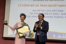 Le ministre vietnamien de la Culture, des Sports et du Tourisme, Nguyen Van Hung, remet la décision de reconduction de Anoa Suzanne Dussol Perran comme ambassadrice du tourisme du Vietnam en France. Photo : VNA.