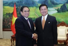 Le PM Pham Minh Chinh (à gauche) et le Secrétaire général du Parti révolutionnaire populaire lao et Président du Laos, Thongloun Sisoulithrencontre. Photo : VNA.
