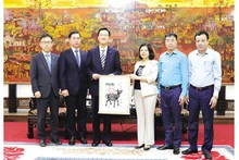 La présidente du Comité populaire provincial, Nguyên Huong Giang, présente un estampe populaire de Dông Hô à Ahn Soon Hong. Photo : baobacninh.com.vn