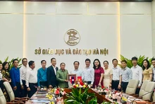 Le dirigeant du Service de l'Éducation et de la Formation de Hanoi présente un cadeau de souvenirs à la délégation du Service de l'Éducation et des Sports de la province de Champassak. Photo : kinhtedothi.vn