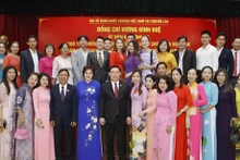 Le Président de l’Assemblée nationale du Vietnam, Vuong Dinh Huê (5e, à partir de la gauche, 1er plan) et les représentants de la communauté vietnamienne au Laos, à Vientiane, le 5 décembre. Photo : VNA.