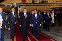 Le Premier ministre chinois Li Qiang (au centre) accueilli à sa descente à l’aéroport international de Nôi Bài, à Hanoi. Photo : VNA.