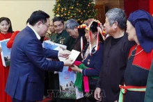 Le Président de l'Assemblée nationale, Vuong Dinh Huê, offre des cadeaux aux personnes bénéficiaires des politiques de l'Etat. Photo : VNA.