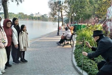 Une famille de trois générations se promène ensemble pour capturer des images joyeuses le premier jour du Nouvel An lunaire. Photo : Quang Tuan/NDEL.
