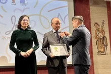 Le président de l'UEVF Nguyen Phan Bao Thuy, remet des insignes à l'ambassadeur du Vietnam en France Dinh Toan Thang et à l'ambassadrice Nguyen Thi Van Anh. Photo : VNA.