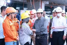 Le Premier ministre Pham Minh Chinh (deuxième à partir de la droite) adresse ses vœux de Nouvel An aux ouvriers du chantier de construction du Terminal 3 de l'aéroport international Tan Son Nhat à Ho Chi Minh-Ville. Photo : VNA.