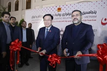 Le Président de l'Assemblée nationale Vuong Dinh Huê (à gauche) et le ministre iranien de la Culture et de l'Orientation islamique, Mohammad Mehdi Esmaili coupent la bande d'inauguration de l'événement. Photo : VNA.