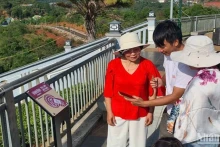 Guide des visiteurs pour effectuer les opérations de check-in sur les panneaux équipés de puces NFC installés dans la ville de Gia Nghia, province de Dak Nông. Photo: nhandan.vn