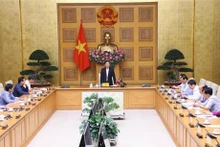 Le Vice-Premier ministre Trân Hông Hà (debout, au centre) lors d e la réunion. Photo : VNA.