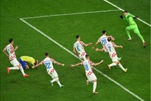 Les Croates célèbrent leur qualification pour les demi-finales de la Coupe du monde 2022, vendredi 9 décembre 2022, à Al-Rayyan (Qatar), après le tir au but manqué du Brésilien Marquinhos, agenouillé. INA FASSBENDER / AFP