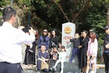 Des touristes visitent la borne 1116, au km No0, à la porte frontalière de Huu Nghi, province de Lang Son. Photo : VNA
