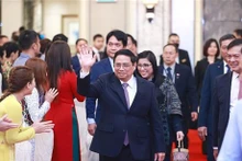 Le Premier ministre Pham Minh Chinh et son épouse lors de la rencontre avec communauté vietnamienne à Singapour, le 8 février 2023. Photo : VNA.