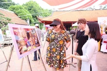 Les touristes visitent l'exposition de photos « Hanoi - 15 ans d'expansion de ses limites administratives » au Temple de la Littérature - Quôc Tu Giam.