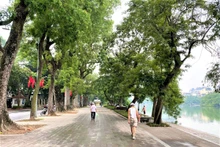 Les gens se promener au bord du lac Hoàn Kiêm. Photo : Thuy Linh.