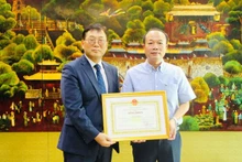 Le vice-président du Comité populaire de la province de Thua Thiên Huê, Phan Quy Phuong (à droite), remet le satisfécit du président du Comité populaire de la province de Thua Thiên Huê au directeur de la KOICA au Vietnam, Cho Han Deog. Photo : NDEL.