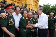 Le Président vietnamien Tô Lâm avec la délégation des personnes ayant rendu des services méritoires à la révolution, à Hanoi, le 22 juillet. Photo : VNA.