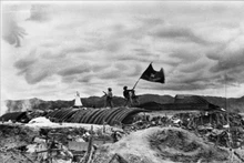 Le drapeau « Déterminé à combattre, déterminé à gagner » de l'Armée vietnamienne flotte au sommet du tunnel de commandement du général français De Castries dans l'après-midi du 7 mai 1954, marquant la victoire complète de la campagne de Dien Bien Phu. Photo d'archives : VNA.