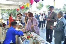 Les visiteurs prennent plaisir à contempler les estampes populaires de Dông Hô et à réaliser ses propres peintures à la laque poncée. Photo: baoquocte.vn