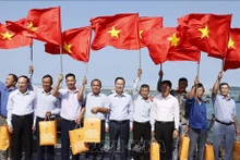 Le Président vietnamien Vo Van Thuong offfre le drapeau national aux pêcheurs du district insulaire de Cô Tô, province de Quang Ninh, au Nord-Est du Vietnam. Photo : VNA.