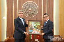 Le rédacteur en chef Lê Quôc Minh offre un tableau commémoratif à Ali Akbar Nazari, ambassadeur extraordinaire et plénipotentiaire de la République islamique d’Iran au Vietnam. (Photo: Khac Anh)