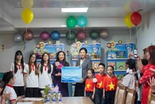 Madame Ngo Phuong Ly offre une bibliothèque de livres vietnamiens à la classe. Photo : NDEL