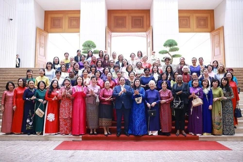 Le Premier ministre vietnamien Pham Minh Chinh et son épouse (en "ao dai" bleu) rencontrent à Hanoi des femmes diplomates vietnamiennes et étrangères en poste au Vietnam. Photo : VNA.
