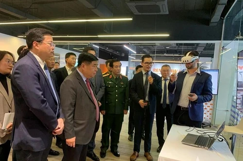 Le vice-Premier ministre Nguyen Chi Dung et les délégués écoutent la présentation du Centre de recherche-développement (R&D) et du Centre d’Excellence consacrés à l’intelligence artificielle et au jumeau numérique. Photo : Quan doi nhan dan