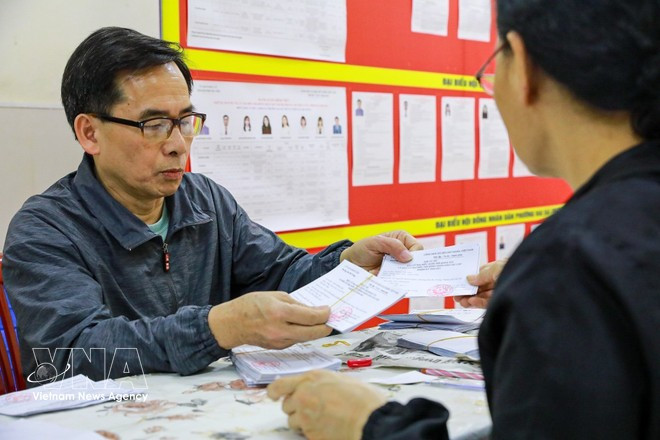 Vérification des cartes d'électeur au bureau de vote n° 3, quartier de Hai Ba Trung, à Hanoï. Photo : VNA