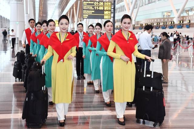 Les hôtesses de l’air, vêtues de foulards rouge étoile d’or, accueillaient les voyageurs avec le sourire dans une ambiance festive. Photo: baoxaydung.vn 10-13.jpg