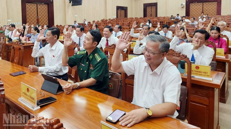 Les délégués du Conseil populaire de la province d’An Giang votent la résolution relative à la décision d’investissement du projet de la première section de la ligne de métro urbain. Photo: nhandan.vn 2.jpg