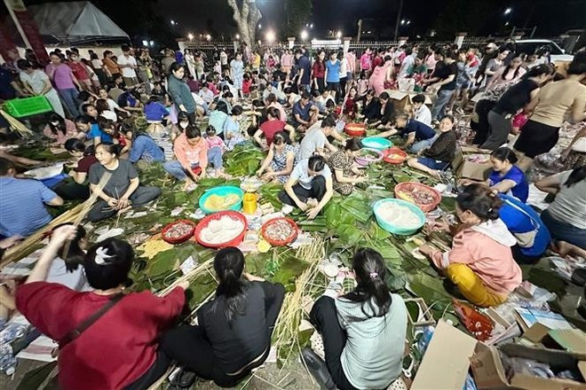 Des centaines de personnes préparent des gâteaux de riz pendant la nuit dans le quartier de Trang Dai, province de Dong Nai, pour envoyer aux sinistrés des inondations. Photo : VNA