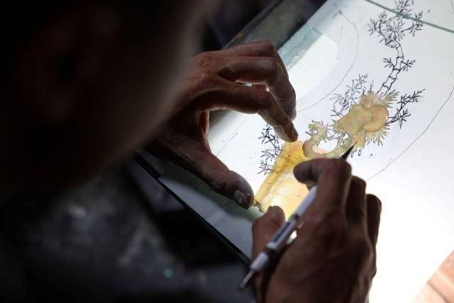 Un artisan ajuste les éléments de nacre avant la gravure – Yen Van. Photo : laodong.vn 2-75.jpg