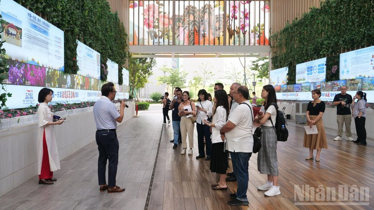 Les visiteurs et consommateurs écoutent des présentations sur le centre CAMEX. Photo: nhandan.vn image-21.jpg