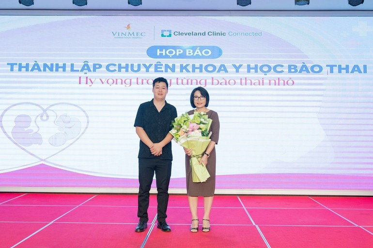 Un représentant de la famille de Mme T.L.C. offre des fleurs en signe de remerciement à la maîtresse de conférences, docteure Đinh Thị Hiền Lê lors de la conférence de presse annonçant la création du Département de médecine fœtale. Photo : nhandan.vn 2.jpg
