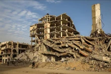 Des habitants marchent au milieu des décombres d'immeubles détruits par le conflit à Gaza. Photo : Xinhua/VNA