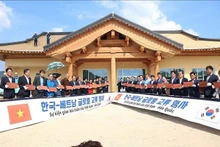 Les délégués sud-coréens et vietnamiens signent des tuiles à contruire le toit de la Maison communautaire de Bonghwa. Photo : VNA.