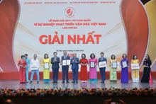 Le vice-Premier ministre Mai Van Chinh (4e, gauche) et le ministre de la Culture, des Sports et du Tourisme, Nguyen Van Hung (6e, gauche), remettent le premier prix aux auteurs et aux groupes d'auteurs lauréats. Photo : VNA.