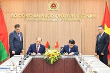 Le ministre vietnamien de la Sécurité publique, le général Luong Tam Quang (droite) et le secrétaire d'État du Conseil de sécurité de la Biélorussie, Volfovich Aleksandr Grigorievich signent un protocole d'accord portant création d'un groupe de travail conjoint visant à élargir et à renforcer la coopération en matière de sécurité. Photo : VNA